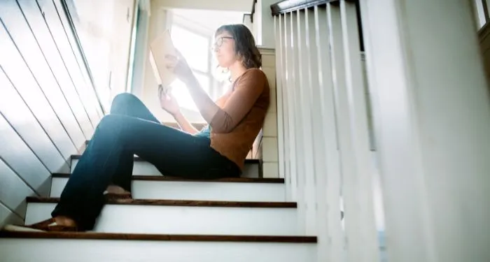 Image of an adult reading on a staircase